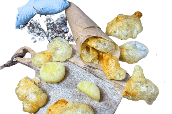 Selbst gemachte Harzer Käse Chips aus dem Backofen und ungebackener Harzer Roller auf einem Holzbrett