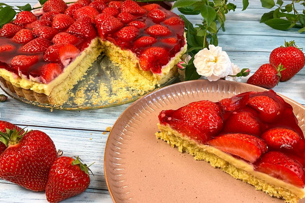 Angeschnittener low carb Erdbeerkuchen mit Pudding ohne Zucker auf Kuchentellern