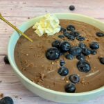Schokoladen Protein Pudding vegan und zuckerfrei in einer Schale mit Heidelbeeren und Schokoraspeln